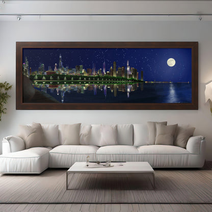The essence of a Chicago summer night. Featuring a digital illustration of the iconic skyline, this framed print showcases a stunning panorama stretching from Shedd Aquarium to Navy Pier, where the large full moon above shines over the glowing city.  Here it is framed in walnut.